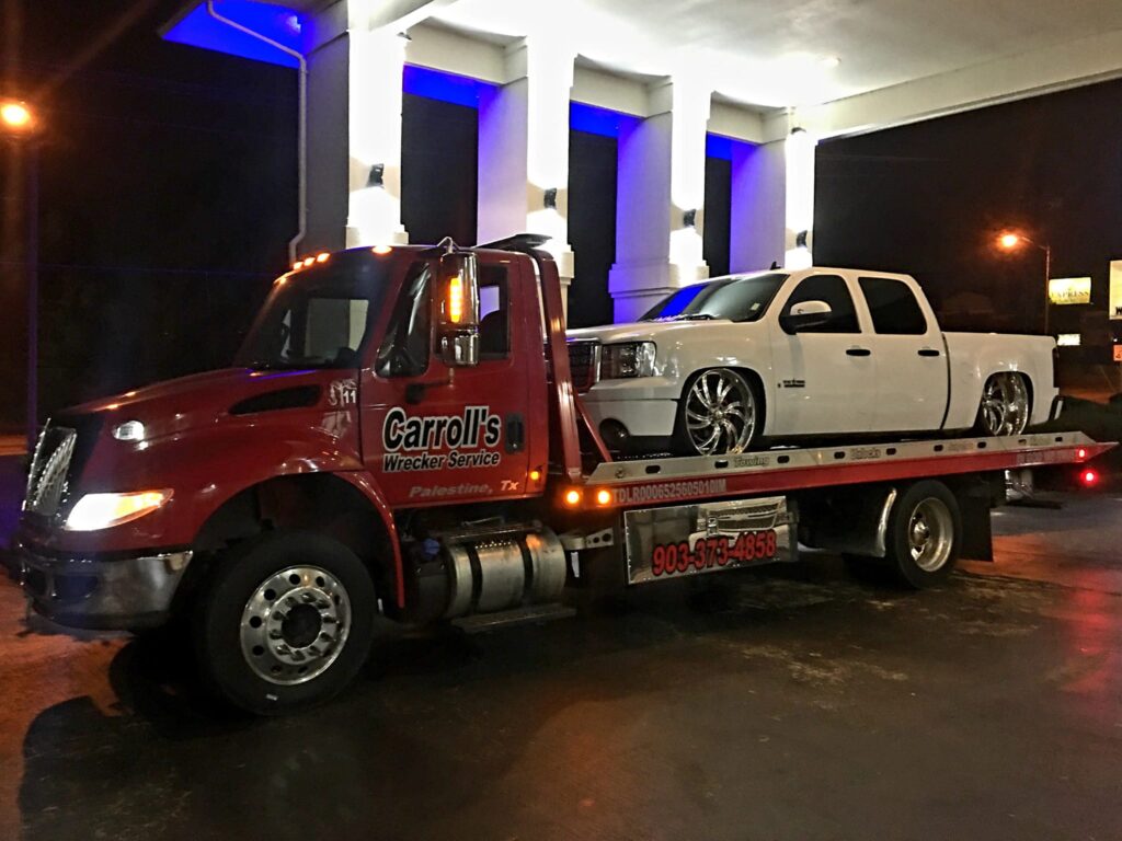 flatbed towing service in Palestine TX loading vehicle at night